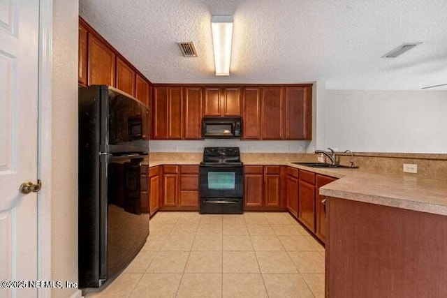 kitchen with light tile patterned flooring, a textured ceiling, sink, and black appliances