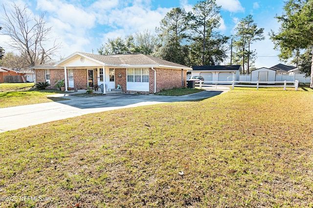 ranch-style home with a garage, an outbuilding, and a front lawn