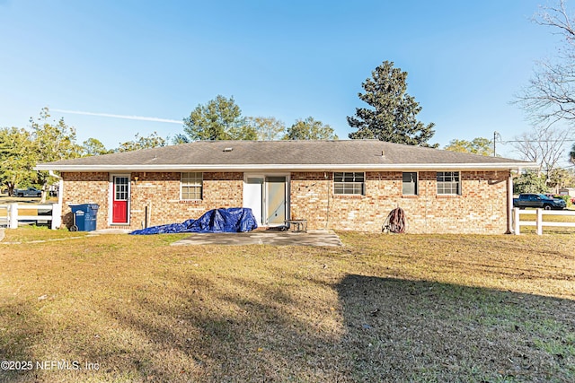 rear view of house featuring a yard and a patio