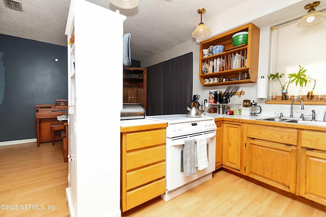 kitchen with white stove, sink, a textured ceiling, decorative light fixtures, and light hardwood / wood-style floors