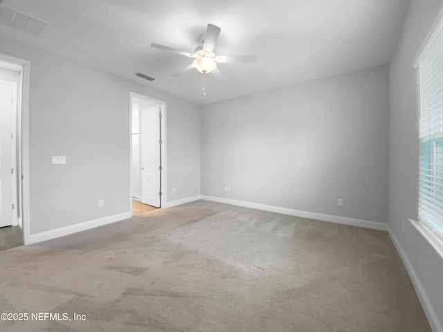 spare room featuring ceiling fan and light carpet