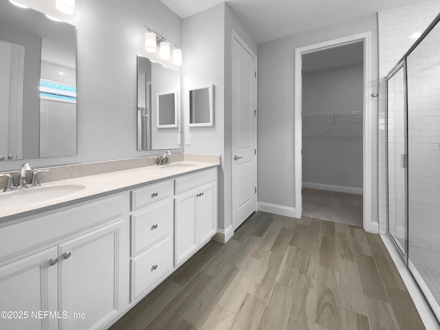 bathroom featuring vanity, a shower with shower door, and wood-type flooring