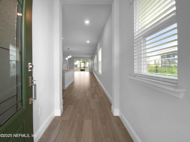 hallway featuring a chandelier and hardwood / wood-style floors