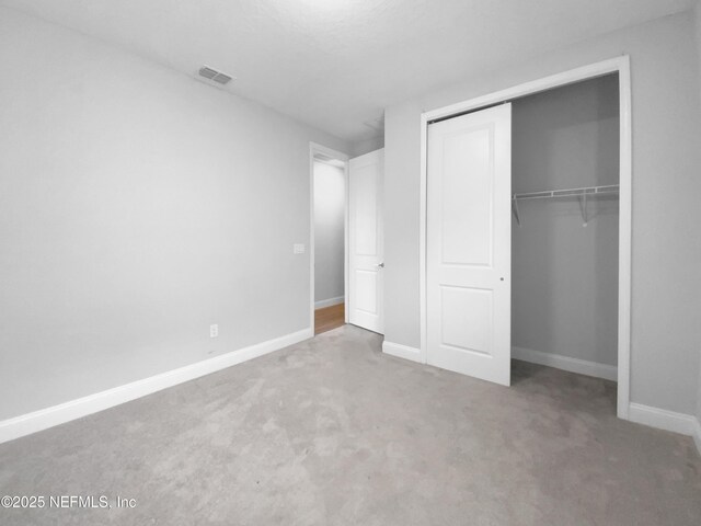 unfurnished bedroom with carpet flooring and a closet