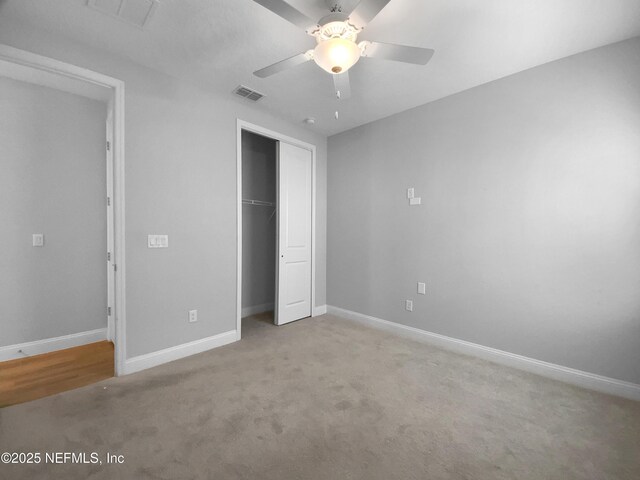 unfurnished bedroom featuring ceiling fan, a closet, and light carpet