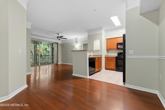 kitchen featuring black appliances, crown molding, sink, ceiling fan, and kitchen peninsula