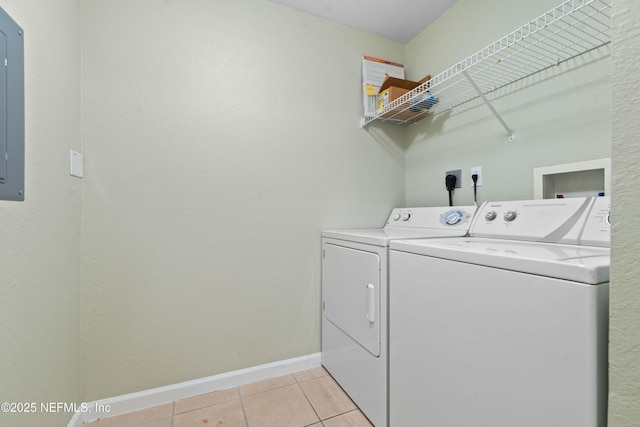 washroom featuring washer and dryer, light tile patterned floors, and electric panel