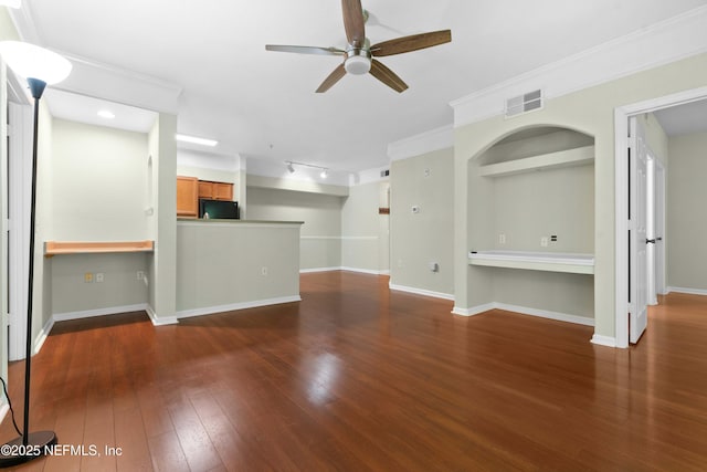 unfurnished living room with ceiling fan, built in desk, ornamental molding, and dark wood-type flooring