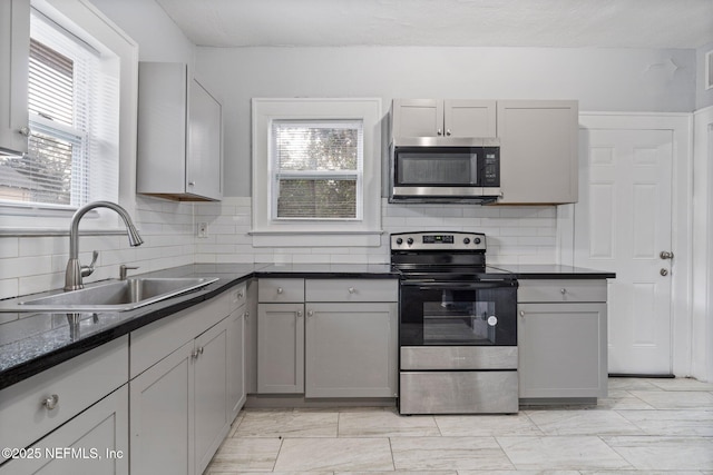 kitchen featuring gray cabinets, a wealth of natural light, sink, and stainless steel appliances