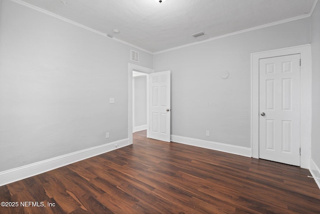 spare room featuring crown molding and dark hardwood / wood-style flooring