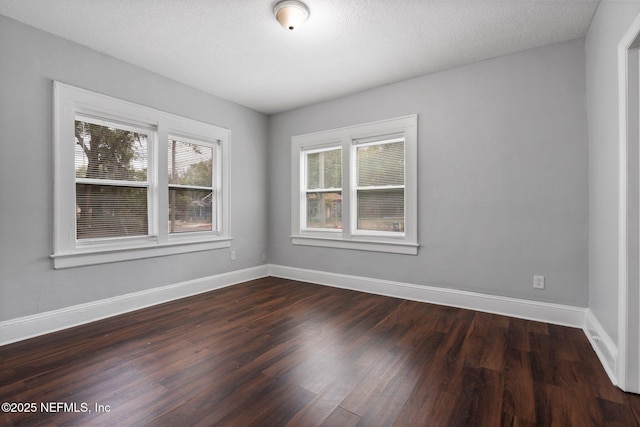 spare room with plenty of natural light, dark hardwood / wood-style floors, and a textured ceiling