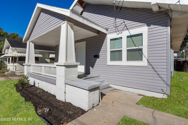 view of side of home featuring covered porch