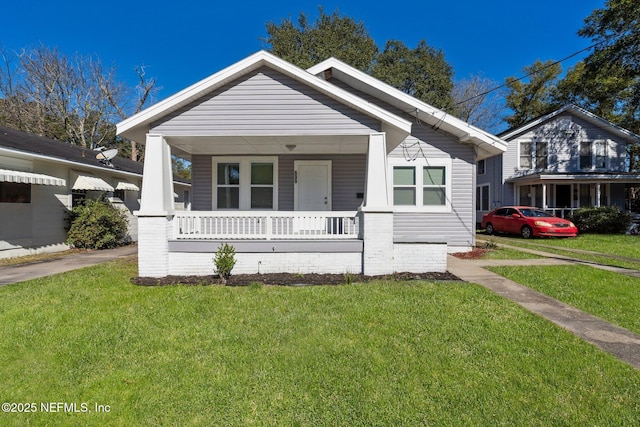 bungalow with covered porch and a front lawn