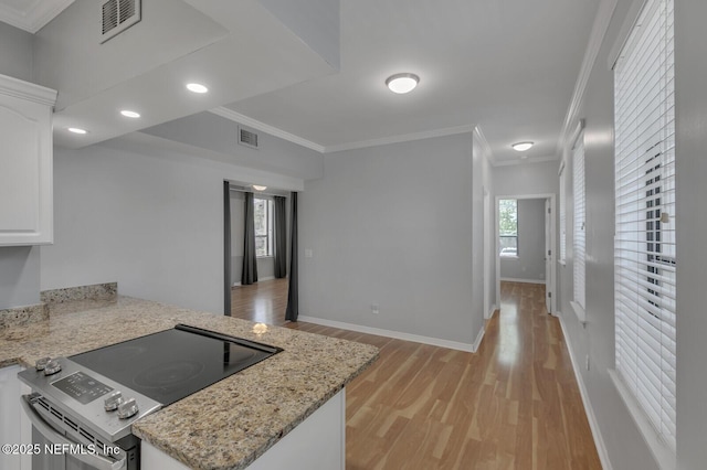 kitchen with white cabinetry, range, light stone counters, crown molding, and light wood-type flooring