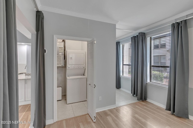 unfurnished bedroom with ornamental molding, light tile patterned floors, and stacked washer / drying machine