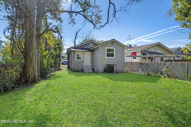 back of property featuring central AC and a lawn