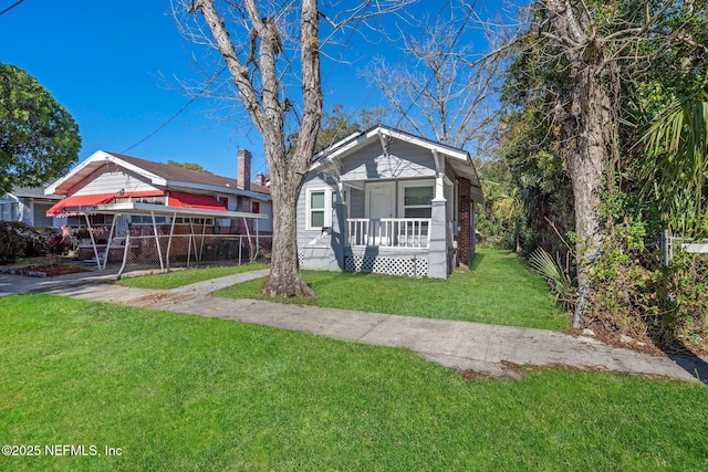 bungalow with covered porch and a front lawn