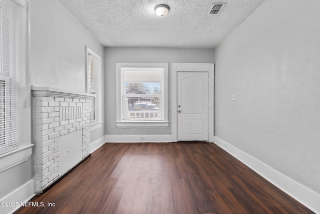 interior space with a textured ceiling and dark wood-type flooring