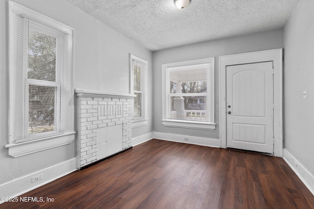 interior space with a textured ceiling and dark hardwood / wood-style flooring