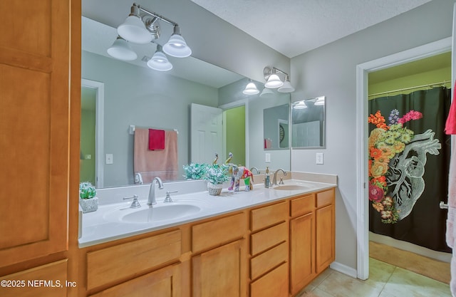 bathroom featuring tile patterned floors, vanity, and a textured ceiling