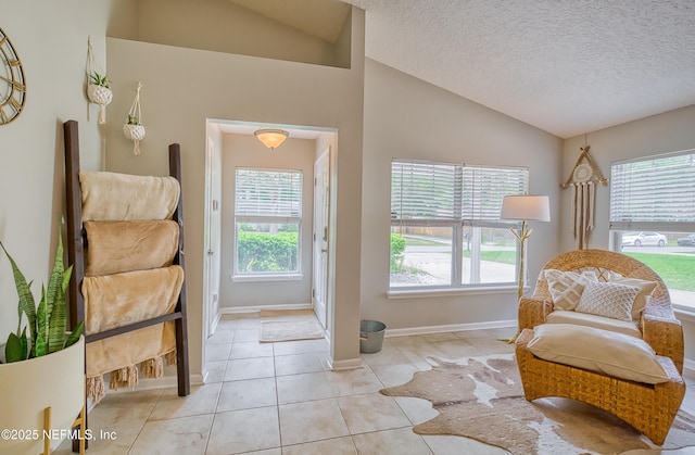 living area featuring a textured ceiling, light tile patterned floors, and lofted ceiling