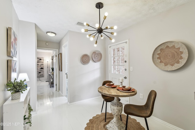 dining room with a textured ceiling and an inviting chandelier