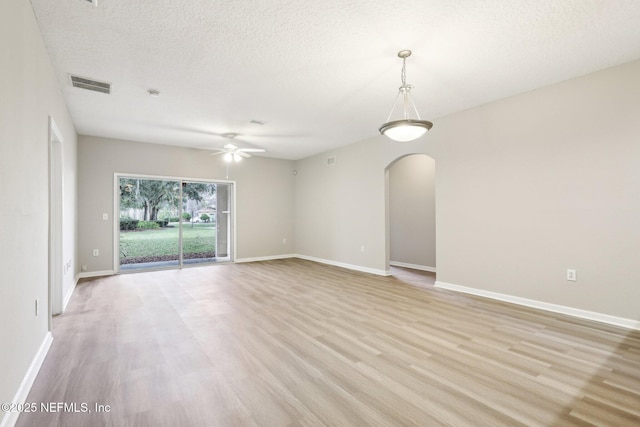 spare room with ceiling fan, a textured ceiling, and light wood-type flooring