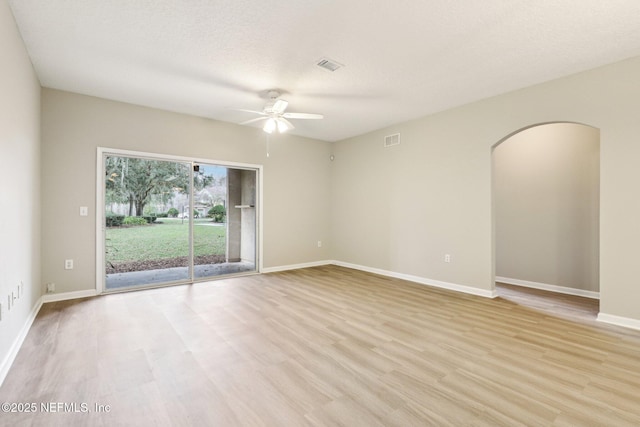 unfurnished room with ceiling fan, light hardwood / wood-style flooring, and a textured ceiling