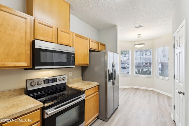 kitchen featuring hanging light fixtures, stainless steel appliances, light hardwood / wood-style floors, and a textured ceiling