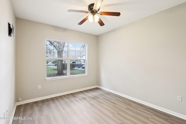 spare room with a textured ceiling, light hardwood / wood-style floors, and ceiling fan