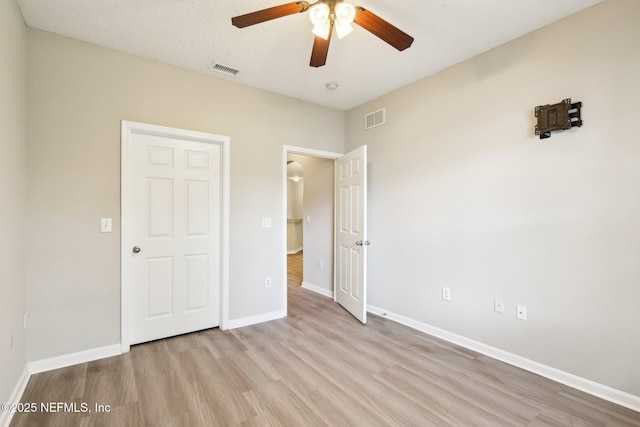 unfurnished bedroom featuring ceiling fan, light hardwood / wood-style flooring, and a textured ceiling