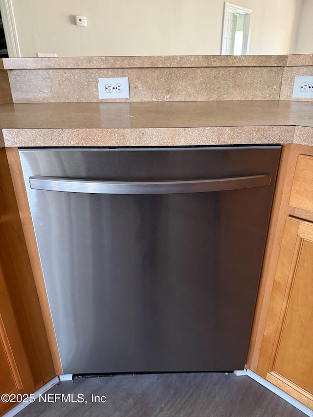 room details with dark hardwood / wood-style flooring and stainless steel dishwasher