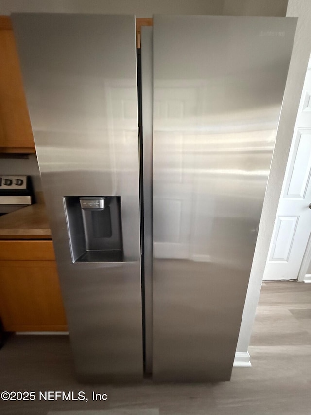 details with stove, stainless steel fridge, and light hardwood / wood-style floors