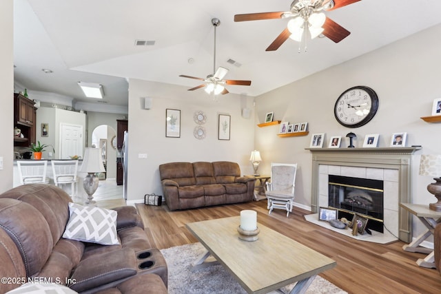 living room with lofted ceiling, hardwood / wood-style floors, and a fireplace