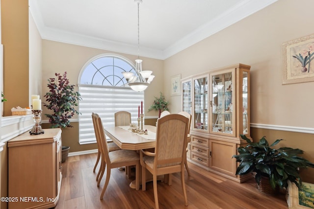 dining area featuring ornamental molding, a chandelier, and hardwood / wood-style floors