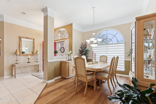 dining room with an inviting chandelier, crown molding, and light hardwood / wood-style flooring