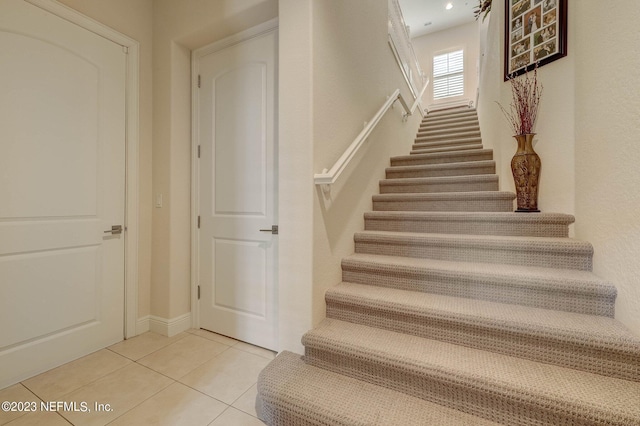 stairway with tile patterned floors