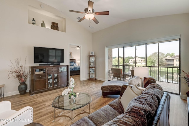 living room featuring ceiling fan, vaulted ceiling, and light hardwood / wood-style flooring