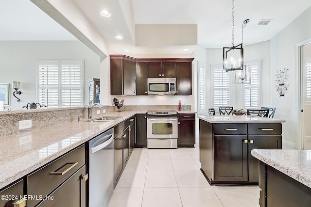 kitchen featuring dark brown cabinetry, stainless steel appliances, sink, pendant lighting, and light tile patterned floors