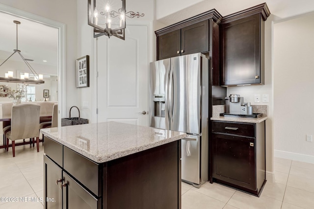 kitchen with light tile patterned floors, stainless steel fridge with ice dispenser, a chandelier, pendant lighting, and a kitchen island