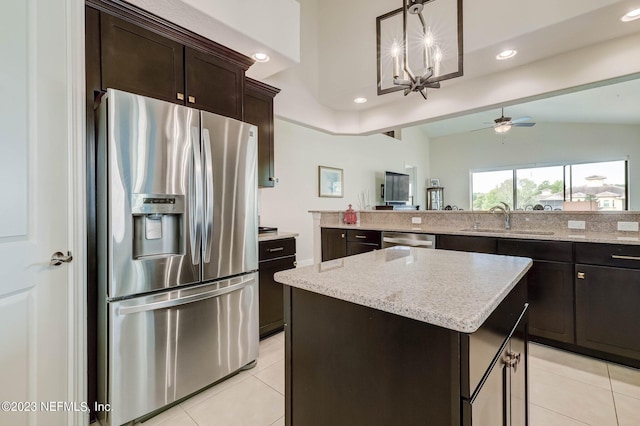 kitchen featuring sink, stainless steel appliances, pendant lighting, a kitchen island, and ceiling fan with notable chandelier