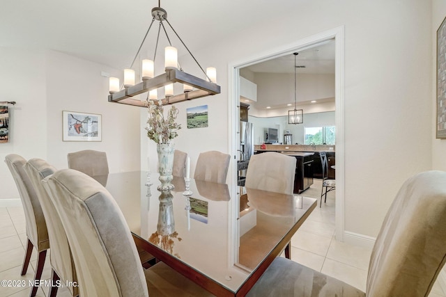 tiled dining space with lofted ceiling and an inviting chandelier