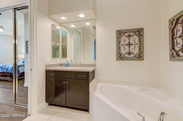 bathroom with tile patterned flooring, vanity, a bathtub, and ceiling fan