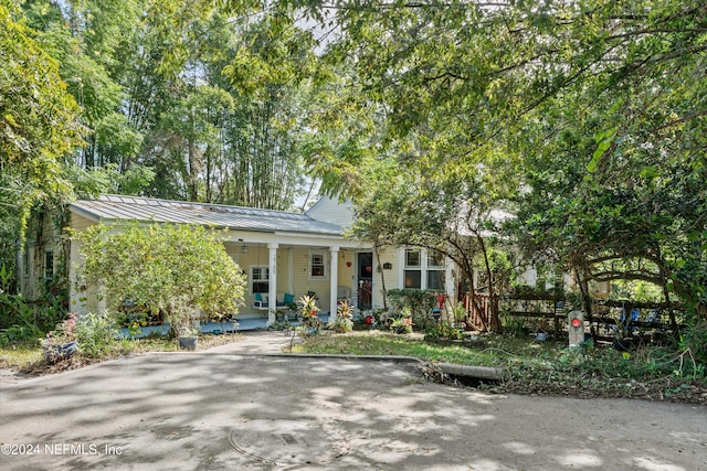 view of property hidden behind natural elements with a porch