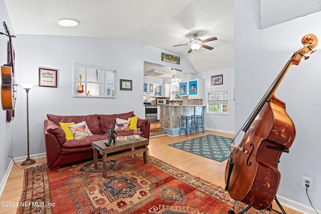 living room with ceiling fan, hardwood / wood-style floors, and lofted ceiling