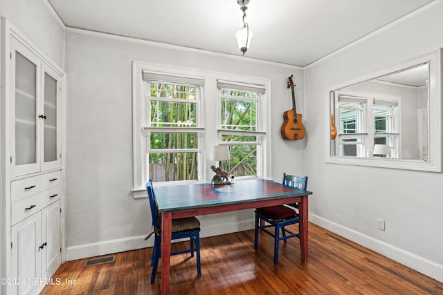 dining space featuring dark hardwood / wood-style flooring and crown molding