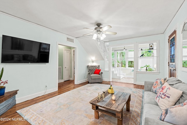 living room with ceiling fan, wood-type flooring, and ornamental molding