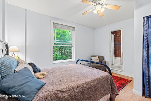 bedroom featuring ensuite bath, ceiling fan, and light hardwood / wood-style flooring