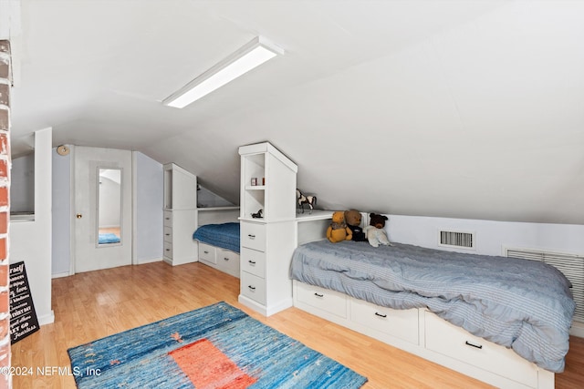 bedroom featuring light hardwood / wood-style floors and vaulted ceiling