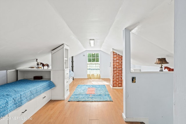 bedroom featuring light wood-type flooring and vaulted ceiling